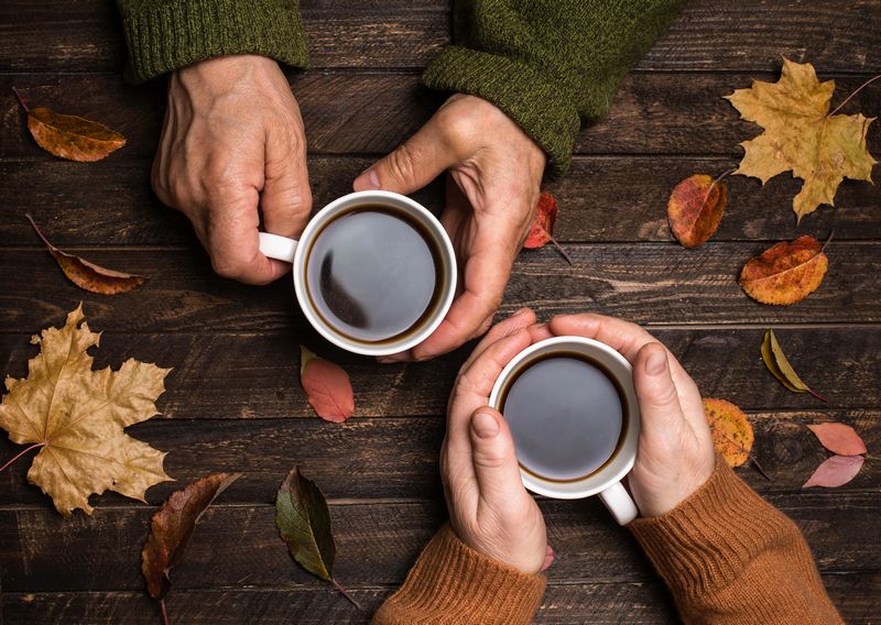 コーヒーカップとお年寄りの手